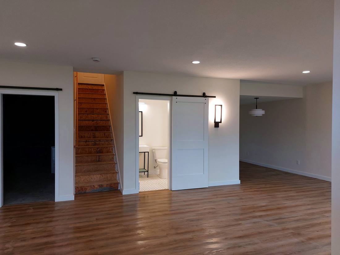 Finished basement with barn door and luxury vinyl flooring