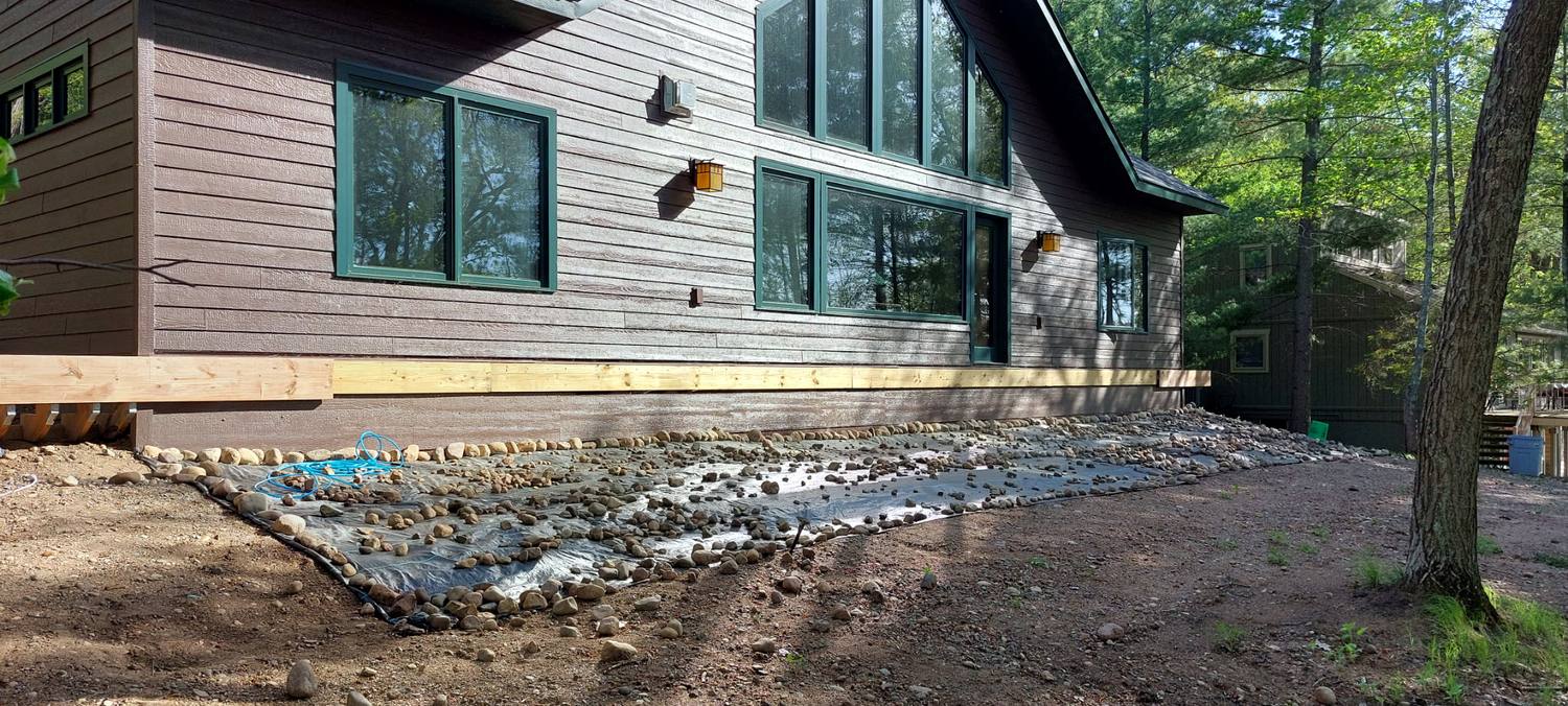 Same home before the deck was built, showing foundation and drainage prep