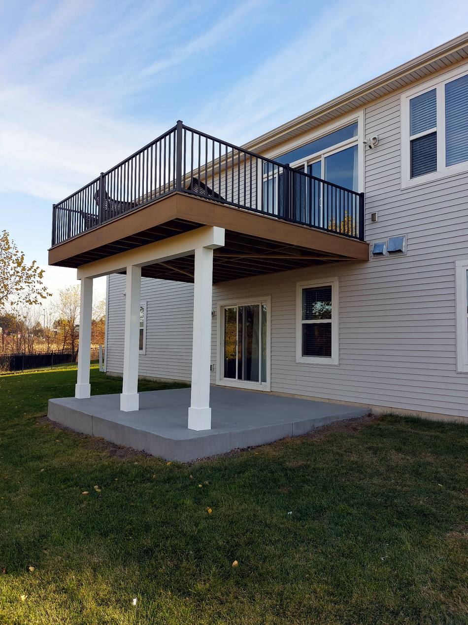 Elevated deck with white columns and covered patio